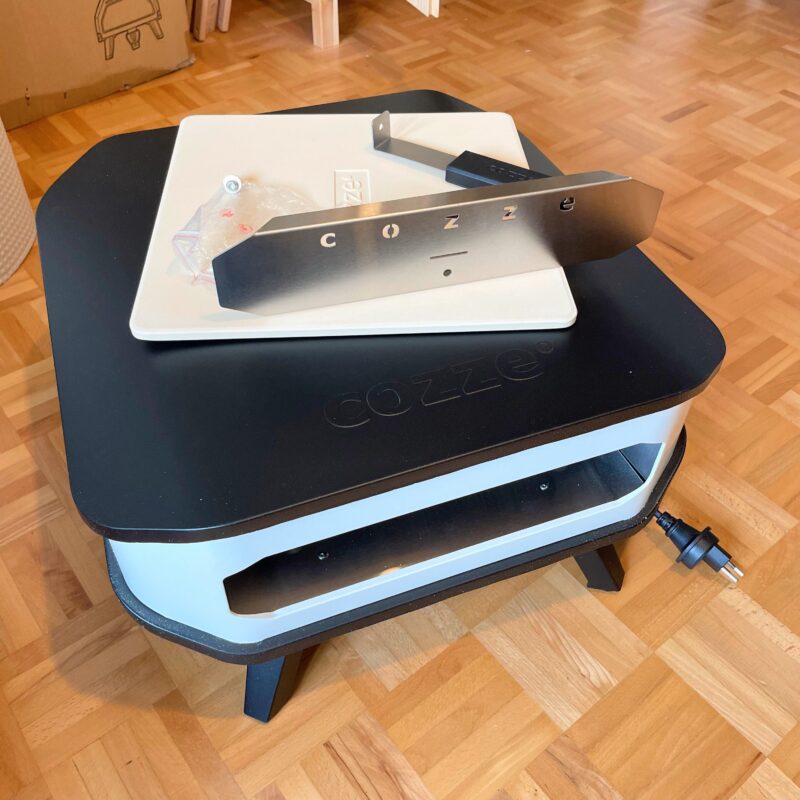 Cozze 13 Elektro nach dem Auspacken mit Pizzastein, Hitzeschild und Zubehör; externe Beispielaufnahme